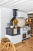 Wood-burning oven and modern stove in a rustic kitchen with white tiles