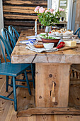Rustic dining table with blue chairs and country-style decorations