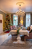 Dining room decorated for Christmas with Christmas tree and chandelier