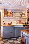 Country-style kitchen corner with grey cabinets and wooden utensils