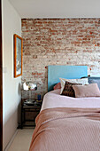 Bedroom with bed in front of exposed brick wall