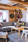 Living room with corner sofa and rustic wooden table, Christmas decorations