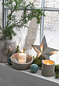 Window sill decorated for Christmas with candles, star and fir branches