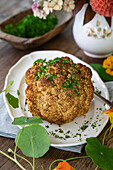 Baked cauliflower with parsley on a white plate and wooden table