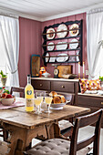 Set dining table, wall shelf with plates, old pink wall colour