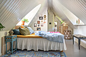 Attic bedroom with colorful carpet and decorative elements