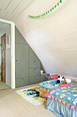 Sloping ceiling with built-in wardrobe, cosy alcove with children's bed