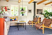 Wohnzimmer mit Ledersesseln, Sofa und blauem Teppich