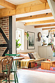 Offener Koch-, Wohn- und Essbereich im Vintage-Stil mit Holzbalken und Ziegelwand