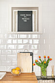 Kitchen unit with letterboard, metro tiles and bouquet of tulips