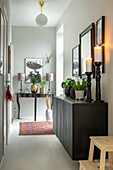 Hallway with furniture and picture frames in black, candles and plants