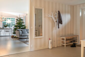 Entrance area with white tree coat hooks and Christmas tree in the background