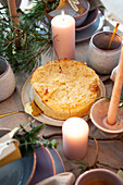 Table set with cake and candles, fir branches as decoration