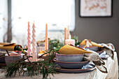 Festive table setting with twisted candles and fir branches