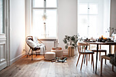 Living room with dining table decorated for Christmas, armchair with fur and pine branches