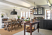 Spacious country kitchen with wooden dining table and dark grey cupboards