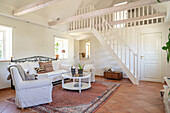 Bright living room with gallery, white couch and oriental carpet