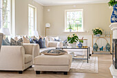 Living room with light-colored sofas and blue decorative accents