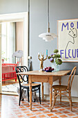 Dining area with wooden table, pendant light and large picture