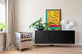 Sideboard with monstera, picture and modern lamp