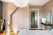 Bedroom with built-in wardrobe and walls in beige and vintage furniture