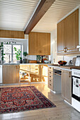 Kitchen with wooden cupboards and oriental rug