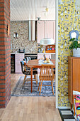 View of the kitchen with dining table, pink cupboards and mosaic tiles