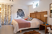 Bedroom with wooden bed and textile art on the wall