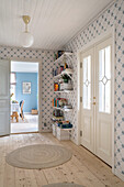 Hallway with geometric wallpaper pattern and wall shelf