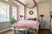 Bedroom with bed, Christmas decorations and red amaryllis