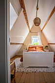 Attic bedroom with white bed and dotted carpet