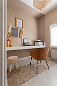 Office corner with leather chair and wall decor in neutral tones