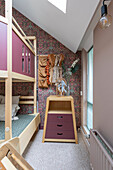 Children's room with bunk bed and floral wallpaper under a sloping roof