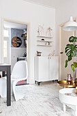 Bright living room with white furniture, golden side table and monstera