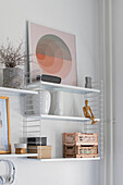 Designer wall shelf with geometric picture and decorative objects