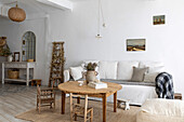 Bright living room with white sofa, rustic wooden table and natural carpet