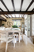 Country-style dining room with beamed ceiling and stone walls