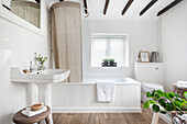Helles Badezimmer mit Badewanne und Holzelementen
