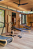 Modern fitness room with wooden paneling and exercise equipment