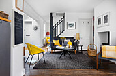Modernes Wohnzimmer mit gelb-schwarzer Farbgestaltung und Holzelementen