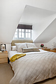 Dachschrägen-Schlafzimmer mit Bettwäsche in neutralen Farben