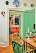 Esszimmer mit grüner Tür und Wandtellern als Dekoration