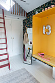 Rote Leiter, kleine Galerie, Spiegel, eingebaute gelbe Nische und dekorative Mustertapete