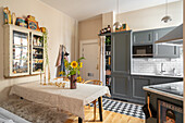 Essbereich im Vintage-Stil mit Vitrinenschrank und grauer Küchenzeile