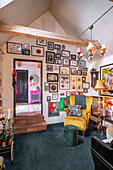 Wohnzimmer mit Galeriewand, gelbem Sessel und vielfältiger Dekoration