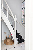 Curved staircase with black stair runner in the hallway
