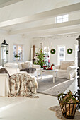 Living room with Christmas decorations, white interior and fireplace