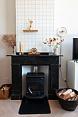 Wood-burning stove framed by a black mantelpiece