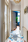 Narrow hallway with colorful floor tiles and leopard rug