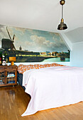 Double bed in the bedroom with photo wallpaper above